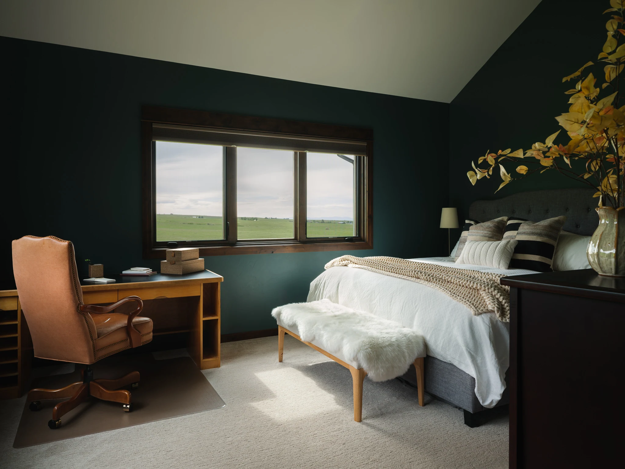 Bedroom with dark green walls, a writing desk, and picture window — interior design photography Livingston Montana, Sam Schlauch Designs